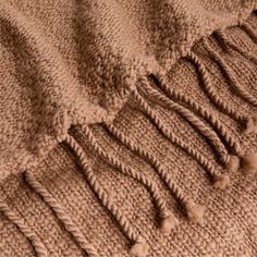 a brown blanket with fringes on the top and bottom is shown in close up