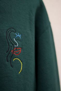 "Lady Luck" embroidered crewneck sweatshirt custom designed by artist Canon Hastings, featuring small embroidered logo on the left chest, and large logo centered on the back. Offered in two colorways, Forest Green and Marble Gray. This sweatshirt is a unisex cut.  This item is made to order Please allow up to two to three weeks to receive your order. Embroidery is executed and shipped by LNN Custom Apparel located in San Diego, California. lnncustomapparel.com Green Long Sleeve Sweatshirt With Machine Embroidery, Green Crew Neck Sweatshirt With Machine Embroidery, Green Crew Neck Sweatshirt With Embroidery, Minimalistic Clothing, Sand Ceremony Set, Sweatshirt Embroidery, Lady Luck, Sand Ceremony, Embroidery Gifts