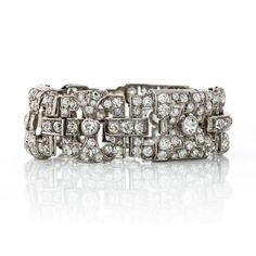 Immerse yourself in the glamour and elegance of the Art Deco era with our exquisite 1930's Platinum Art Deco Open Work Diamond Bracelet. Crafted with precision and adorned with a magnificent display of old European cut diamonds totaling an impressive 22 carats, this bracelet is a true embodiment of timeless beauty.The intricate openwork design of this bracelet captures the essence of Art Deco aesthetics, showcasing geometric patterns and delicate craftsmanship. Each diamond is carefully set to e Art Deco Platinum Diamond Bracelet, Art Deco White Gold Jubilee Diamond Bracelet, Art Deco White Gold Diamond Bracelet, Vintage Diamond Bracelet With Hand-set Diamonds, Vintage Hand Set Diamond Bracelet, Art Deco Diamond Bracelet With Accents, Vintage Diamond Jubilee Bracelet, Art Deco White Gold Bracelets For Evening, Art Deco Diamond Bracelets For Anniversary