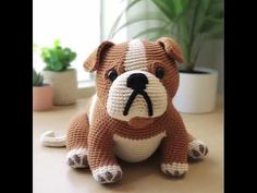 a brown and white stuffed animal sitting on top of a table next to a potted plant