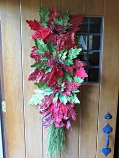 red and green poinsettia hanging from the side of a door