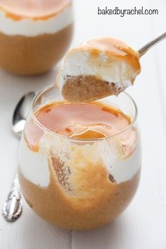 a dessert in a small glass bowl with a spoon sticking out of the top and saucer on the side