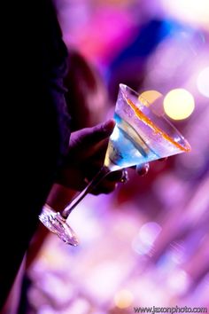 a person holding a martini glass in their hand