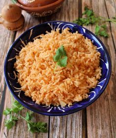 a blue and white bowl filled with rice on top of a wooden table