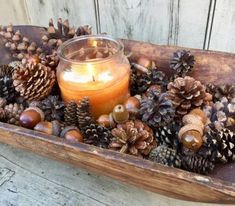 a candle and some pine cones on a tray