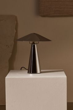 a table lamp sitting on top of a white block