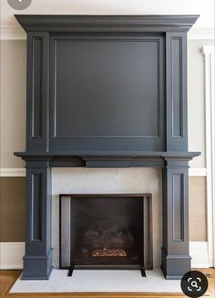 a fireplace with a tv above it in a room that has wood floors and white walls