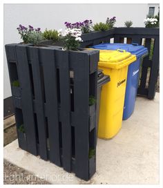 two trash cans are sitting next to some planters