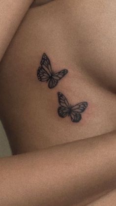 two butterflies on the side of a woman's stomach, one is black and white