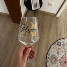 a person holding up a wine glass with the word previnia written on it