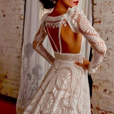 the back of a woman's dress is shown in front of a brick wall