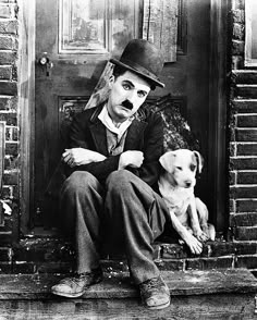 a man sitting on the steps with his dog in front of him wearing a top hat