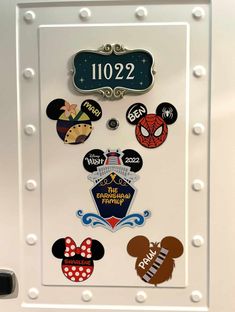 mickey mouse magnets are on the back of a refrigerator door with numbers and symbols