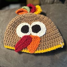 a crocheted turkey hat with big eyes