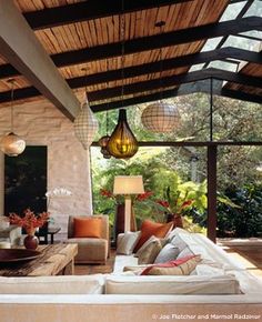 a living room filled with furniture under a wooden roof