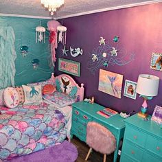 a bedroom with purple and blue walls, mermaid themed bedding, and other decorations