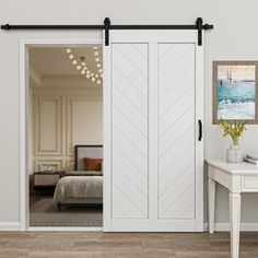 an open white sliding door in a bedroom next to a table with a vase on it