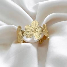 Make a statement with our chunky floral cuff bracelet thats easy to wear and style. Wear alone or layer with other bracelets. 14k Gold Filled Cuff Diameter: 52mm x 34mm Adjustable Hypoallergenic Water resistant & tarnish free Nickel & lead free Gold Bracelet Jewelry For Spring, Spring Gold Bracelet Jewelry, Gold Spring Bracelet, Gold Bangle Bracelets For Spring, Gold Bangle Bracelet For Spring, Adjustable Flower Cuff Bracelet For Spring, Spring Wedding Bangle Bracelets, Elegant Spring Bracelets In Flower Shape, Elegant Flower-shaped Bracelets For Spring