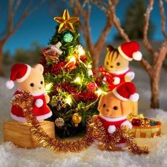 three teddy bears are sitting in front of a christmas tree with lights and decorations on it