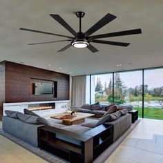 a living room with a large couch and ceiling fan