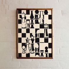 a black and white chess board is hanging on the wall