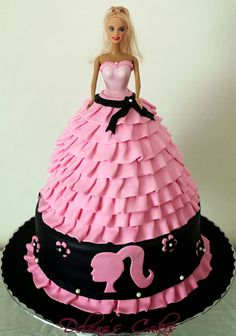 a barbie doll cake with pink and black ruffles