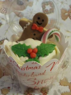 a cupcake in a box with a gingerbread man on it's head