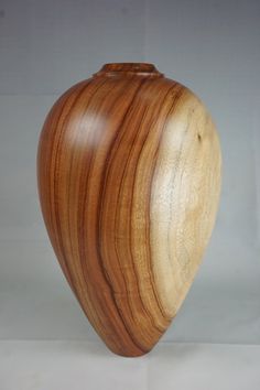 a wooden vase sitting on top of a white table