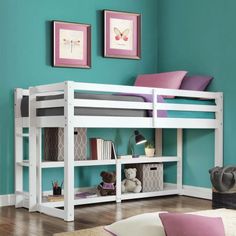 a white bunk bed sitting on top of a wooden floor next to a blue wall