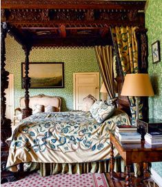 a bedroom with green wallpaper and a canopy bed in the middle, along with a rug on the floor