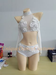 a mannequin wearing a white bra and panties on top of a wooden table