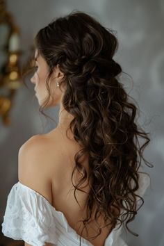 a woman with long curly hair in a white dress looking off to the side,