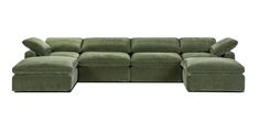 a green sectional couch with pillows on it's back and foot rest in the middle