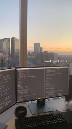 two computer monitors sitting on top of a desk in front of a window with the words work work