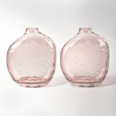 two pink glass vases sitting side by side