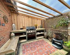 an outdoor kitchen with grill and potted plants