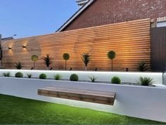 a wooden bench sitting in the middle of a grass covered yard next to a fence