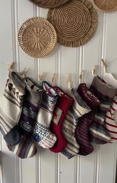 a bunch of socks are hanging on the wall next to some baskets and rugs