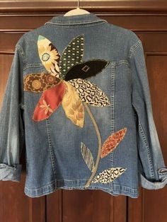 a denim jacket with flowers and leaves on it