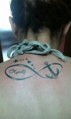 the back of a woman's neck with an anchor and name tattoo on it