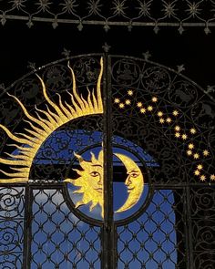 the sun and moon are seen through an iron gate with intricate designs on it's sides