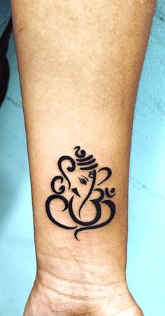 an elephant tattoo is on the wrist of a person's arm, which has a small gandapa