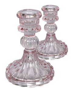 two clear glass candlesticks sitting next to each other