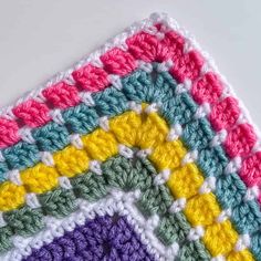 a crocheted square with multicolored squares on the top and bottom half