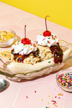 a banana split with ice cream, sprinkles and cherries on top