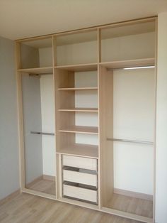 an empty walk in closet with white walls and wooden flooring on the other side