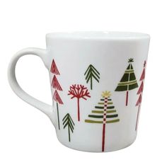 a white coffee cup with trees painted on it