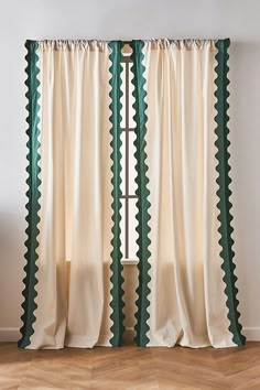 an open window with green scalloped trim and white curtains in front of a wooden floor