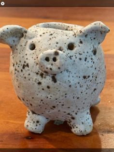 a ceramic pig sitting on top of a wooden table