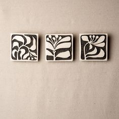 three black and white tiles with flowers on them